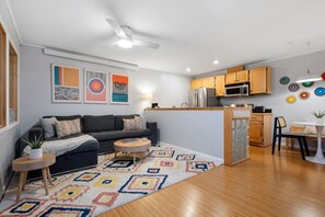 A modern apartment with a living room, kitchen, and dining area.