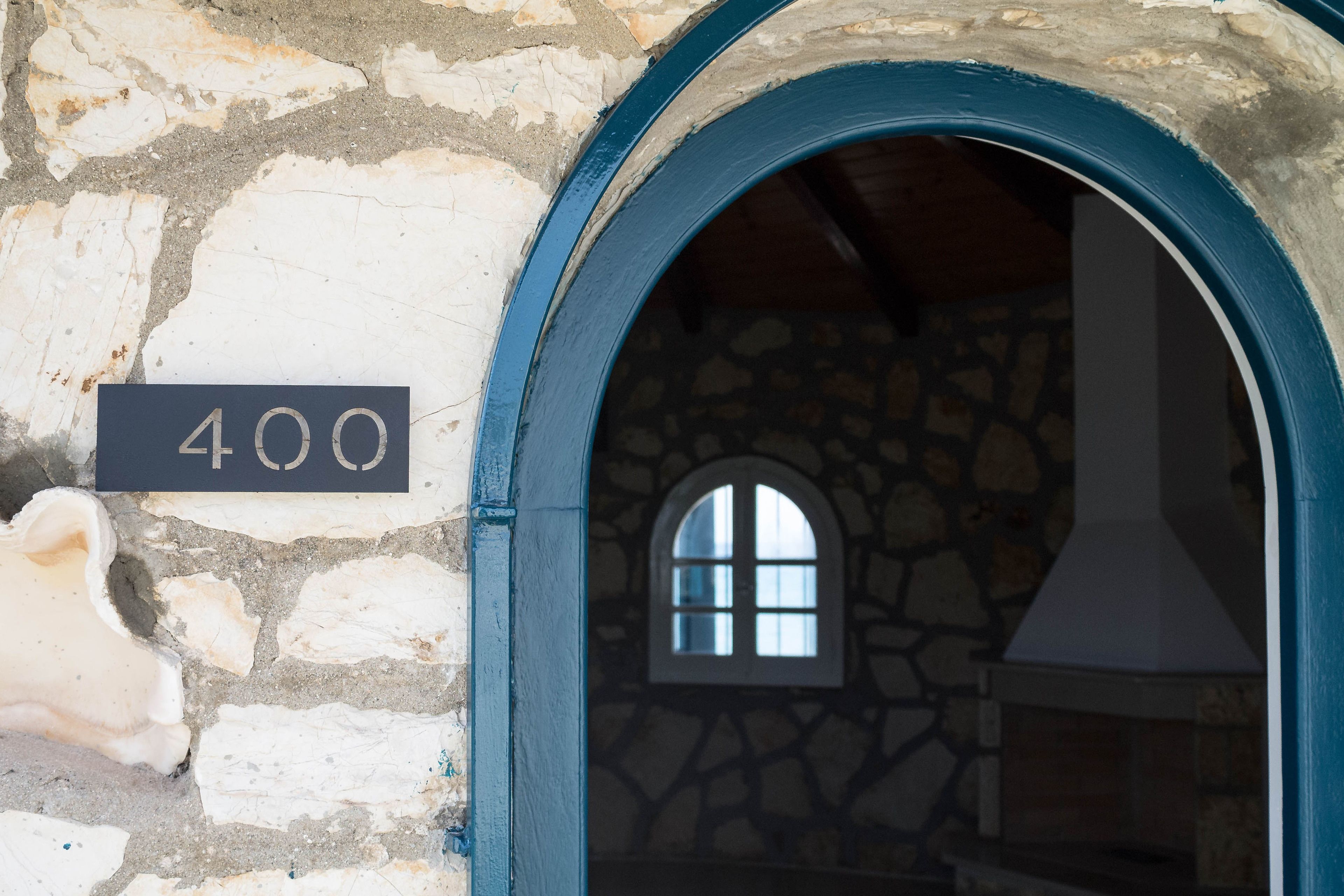 Un edificio de piedra con un letrero que dice "400" y una ventana con un muro de piedra.