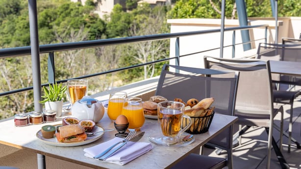 A breakfast table with various food items, drinks, and a view of a mountainous landscape. - Hotel Sainte Victoire (Vauvenargues)