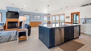 A modern kitchen with a large island, built-in appliances, and a view of the outdoors. - Wise Choice: Semi-oceanfront | Private Pool | Spa (Nags Head)
