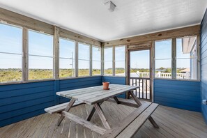 A covered outdoor area with a wooden picnic table and a potted plant. - Wise Choice: Semi-oceanfront | Private Pool | Spa (Nags Head)