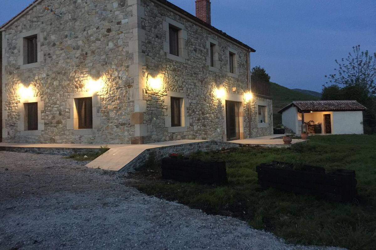 Un edificio de piedra con varias ventanas y una pequeña estructura adosada.