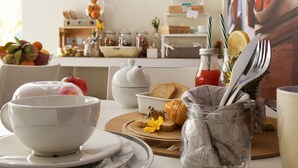 A breakfast setting with bowls, bread, a bottle, and utensils on a table. - Casa Borgo Regina B&B Bari (Noicattaro)