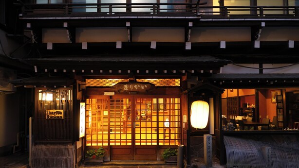 A traditional Japanese building with a wooden entrance, a signboard, and a lantern. - Ikariya Ryokan (Yamanouchi)