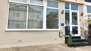 Un immeuble avec une enseigne indiquant « Empress Select Holiday Flats » et une autre indiquant « Complet ».