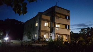 Un edificio de varios pisos con techo plano y un balcón en el nivel superior.