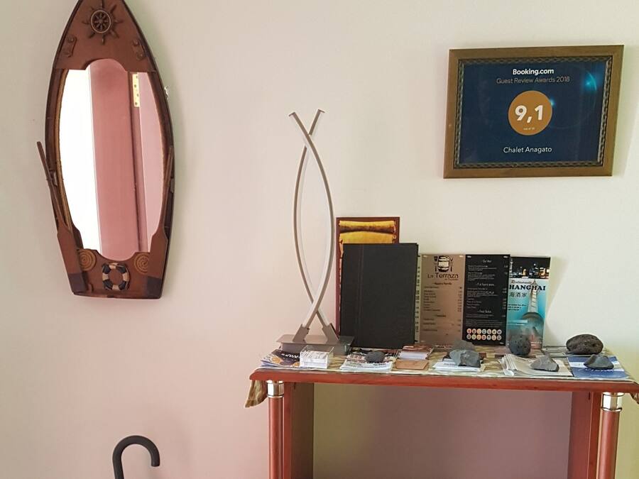 A wooden bookshelf with various items including books, a framed certificate, and a mirror.