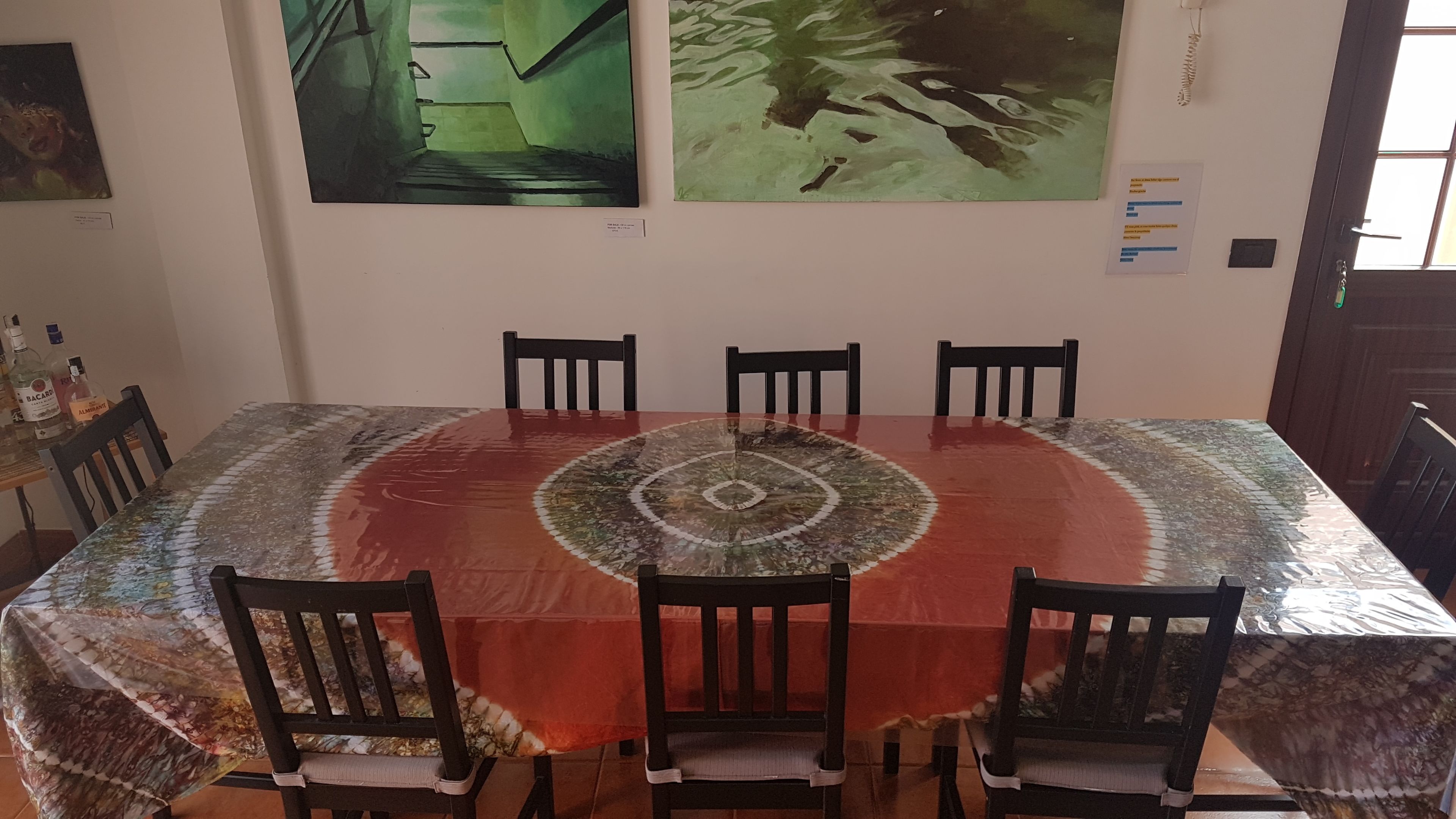 Un tavolo da pranzo con una tovaglia decorata, circondato da sei sedie.
