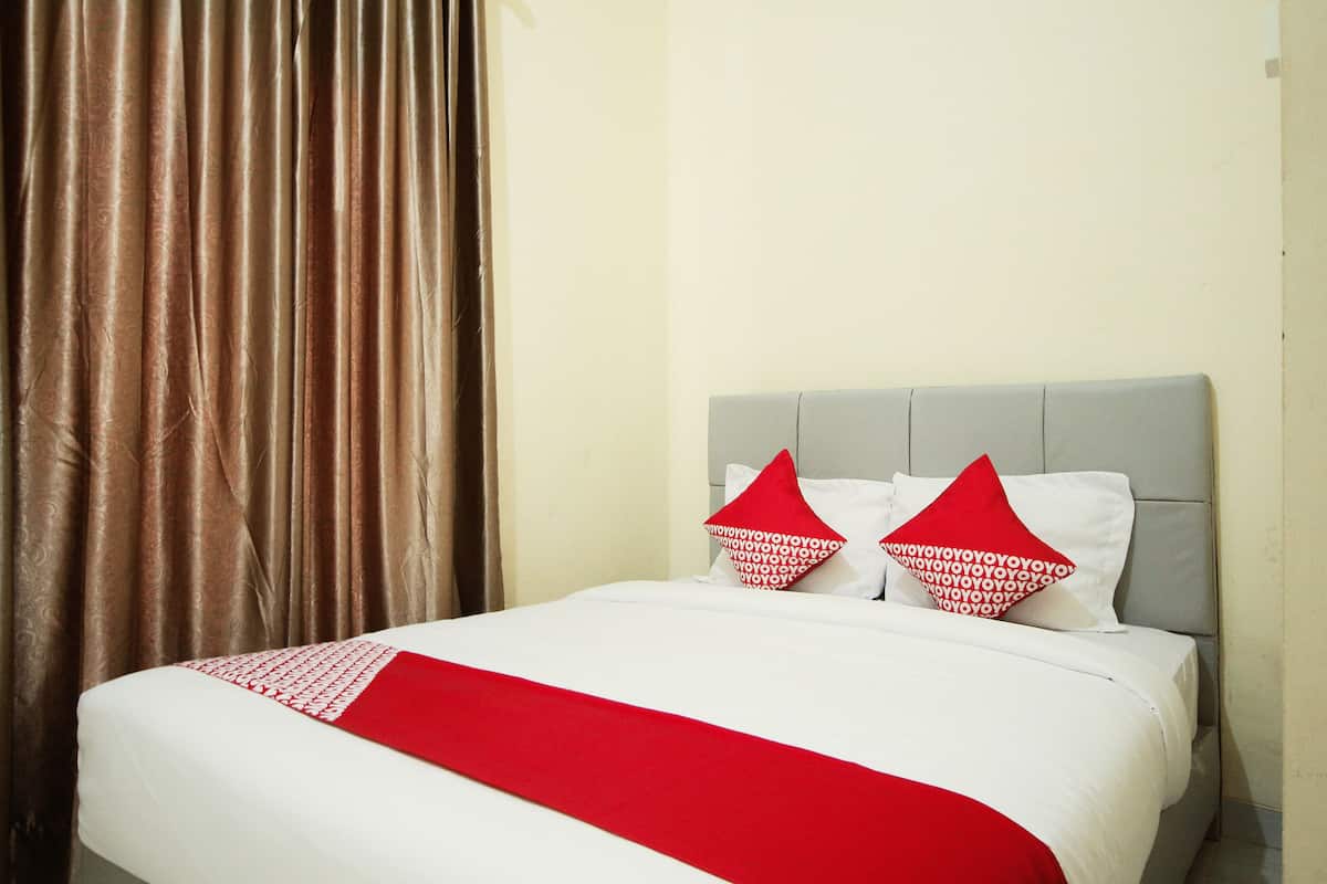 A hotel room with a bed, curtains, and pillows.
