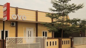 A building with a large sign reading "OYO" and a gated entrance. - OYO 654 Fabio Guest House Syariah (Bandar Lampung)