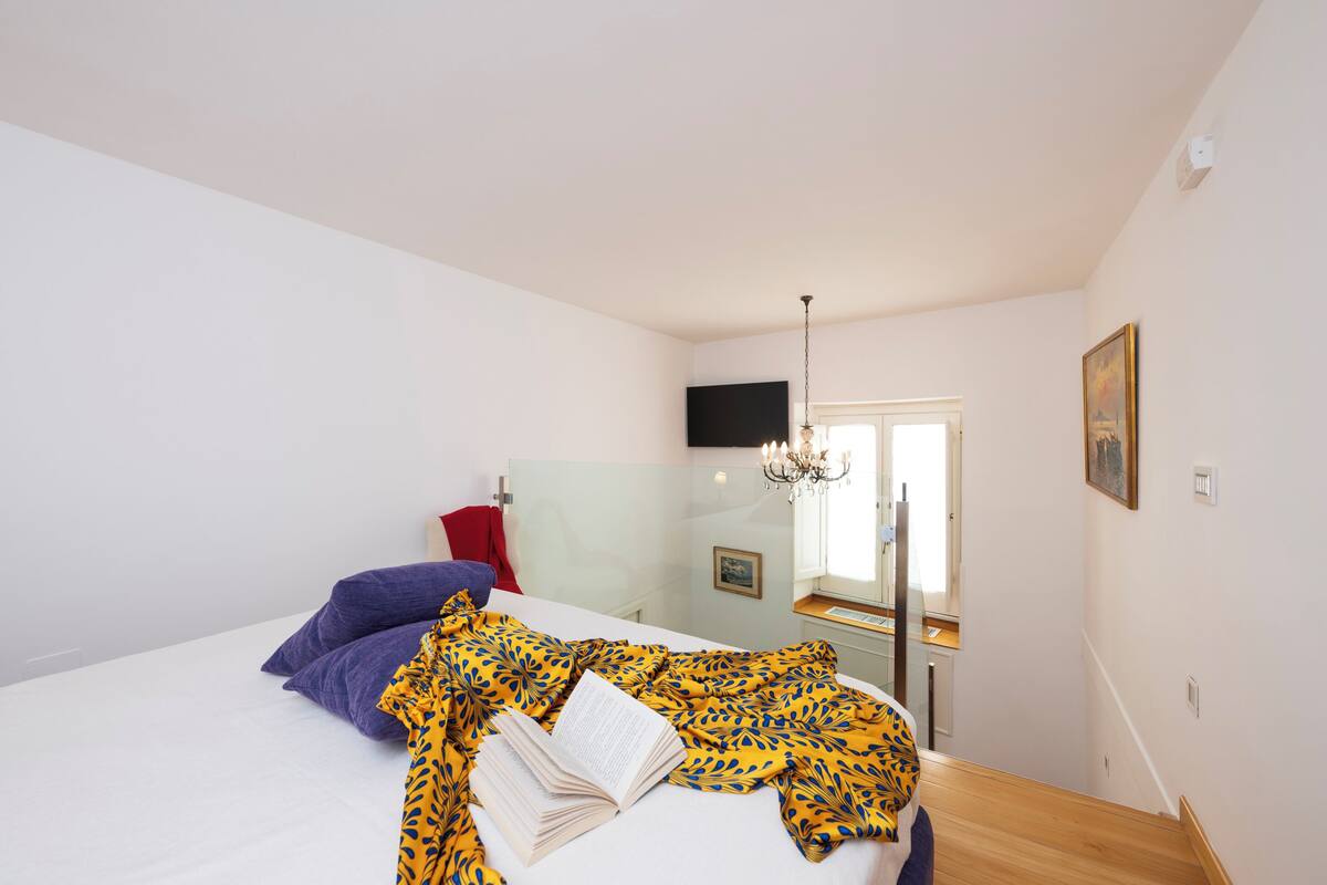 A bedroom with a bed, a book, and a patterned blanket.