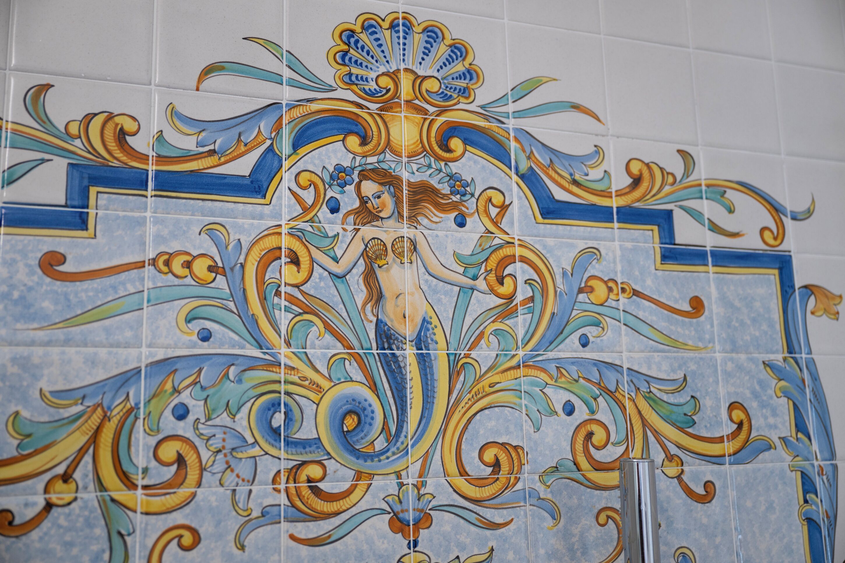 Un muro rivestito di piastrelle con decori floreali e geometrici.