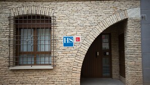 Ein Steinhaus mit einem Schild mit der Aufschrift "HS" und einem teilweise sichtbaren Schild, auf dem "HOTEL" steht.