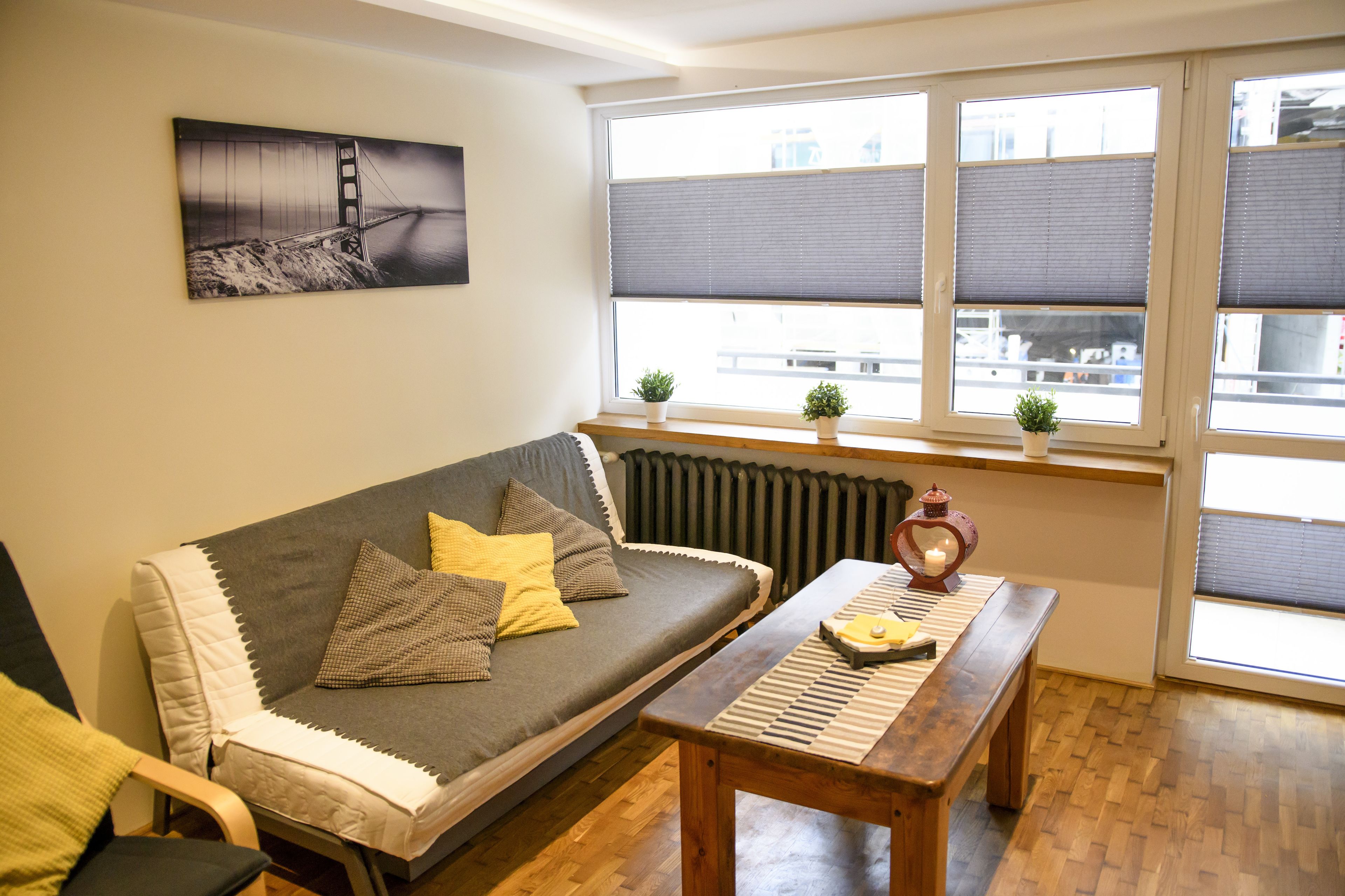 A cozy living room with a sofa, a wooden table, and a radiator.