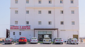 Ein mehrstöckiges Hotel mit einem Schild, das einen Restaurant- und Coffeeshop im Erdgeschoss anzeigt.