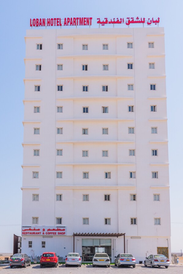 A multi-story hotel with a sign indicating it is a hotel apartment.