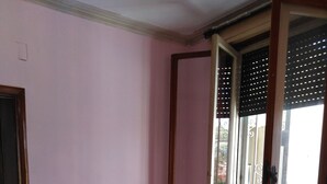A room with a checkered floor, a sliding glass door, and a bed with a green cover. - B&B Parioli Roma (Rome)