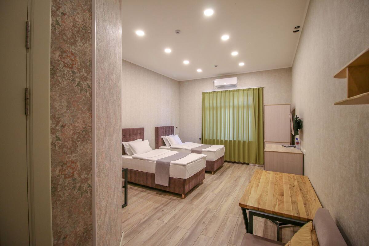 Premium bedding, desk, laptop workspace, blackout drapes