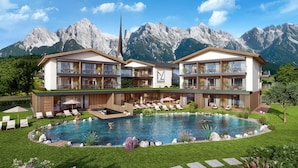 Ein modernes Hotel mit Pool, zweistöckiger Bauweise und Bergblick.