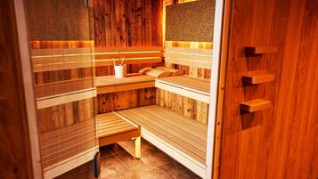 A sauna with wooden benches and a bench with a towel and cup.