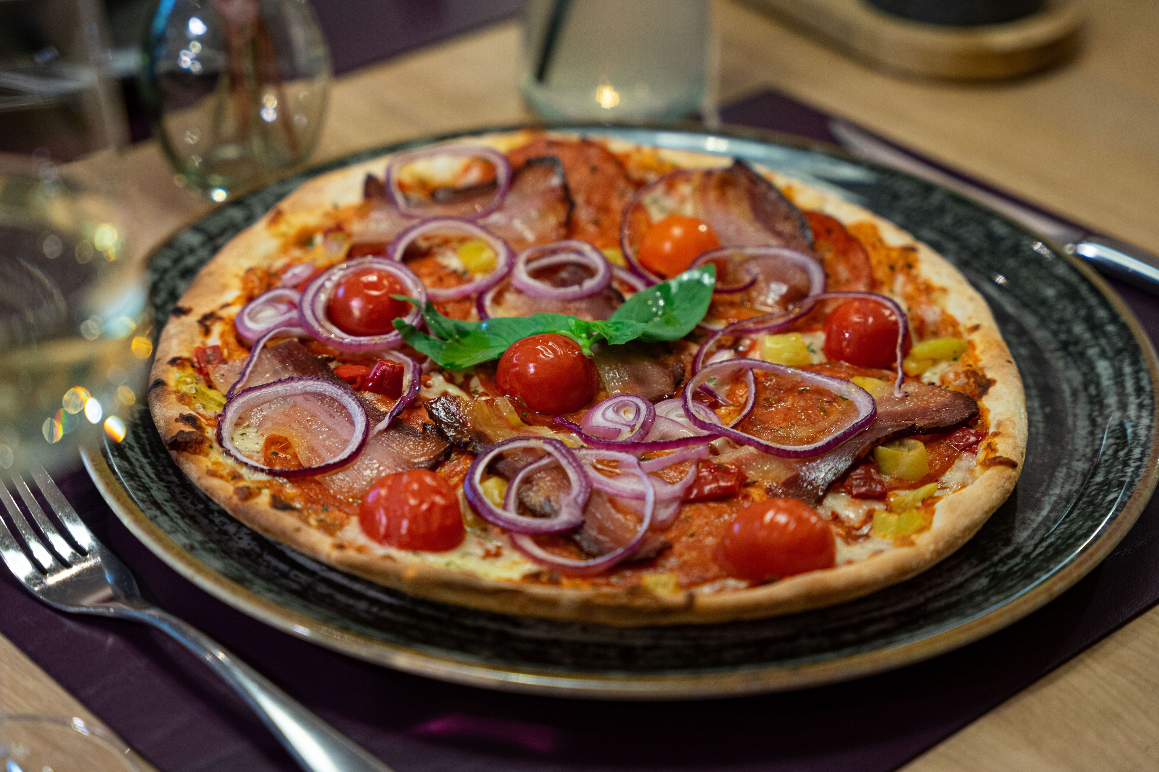 Eine Pizza mit Belag auf einem Teller.