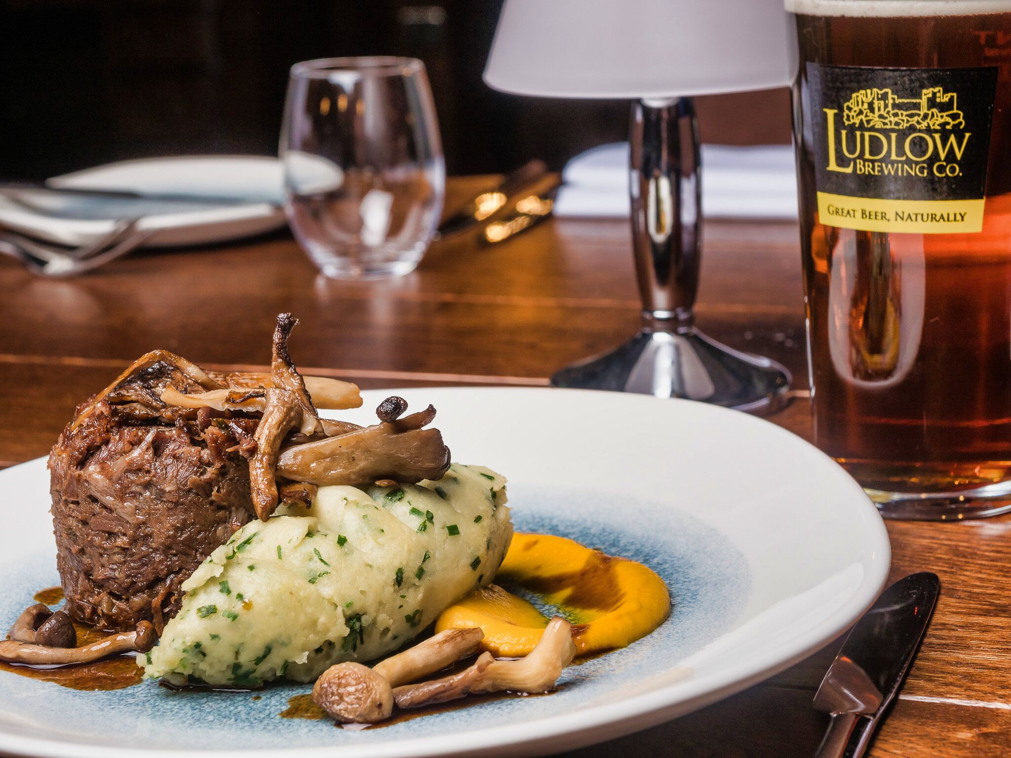 Un plato de comida con un vaso de cerveza.