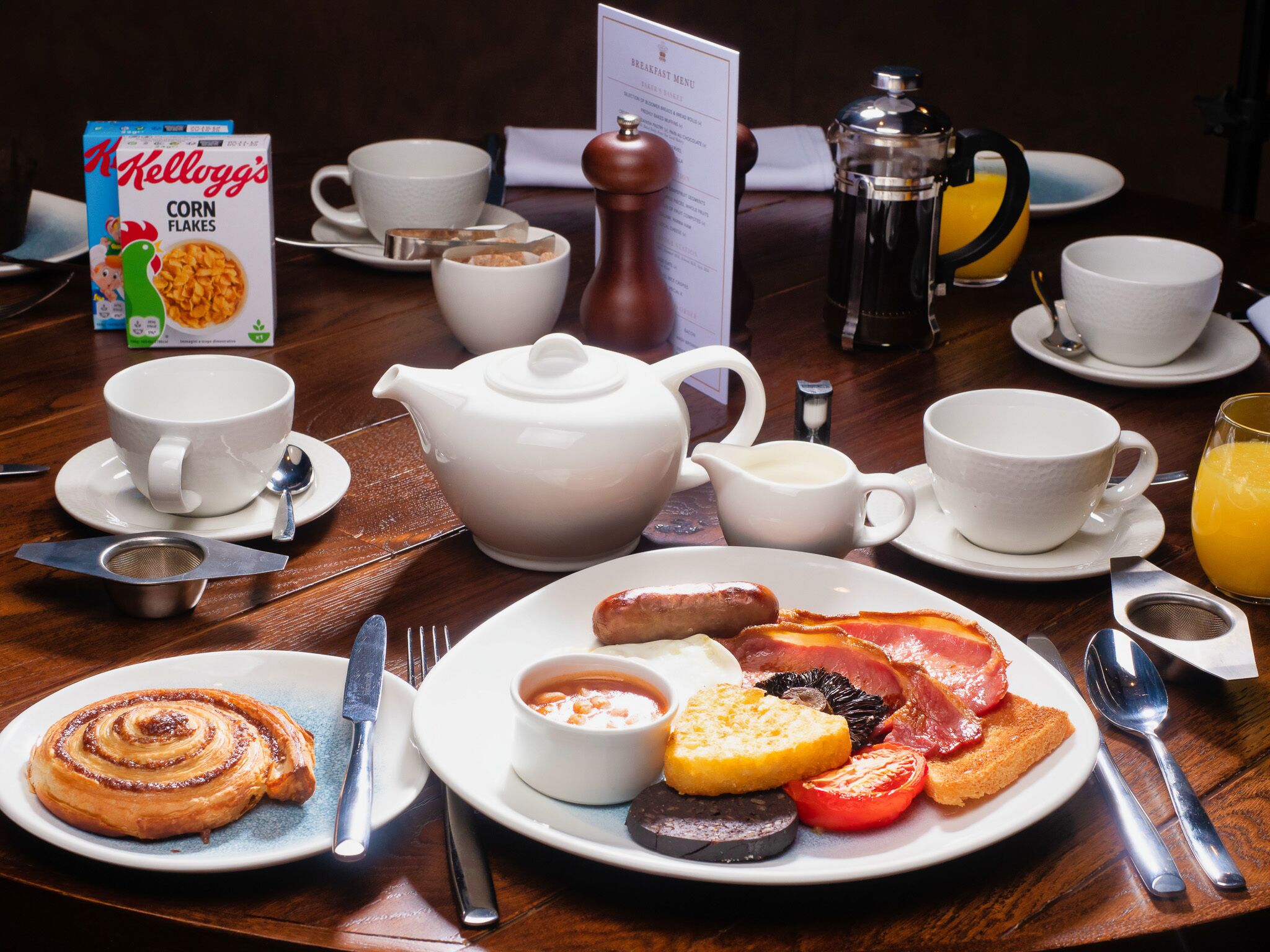 A breakfast setting with a coffee pot, teapot, and a menu.