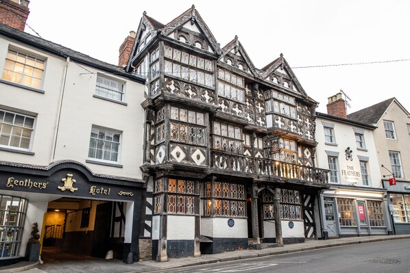 A traditional half-timbered building with a sign for "The Feathers Tea Room" and "Leathers Hotel." - The Feathers Hotel (Ludlow)