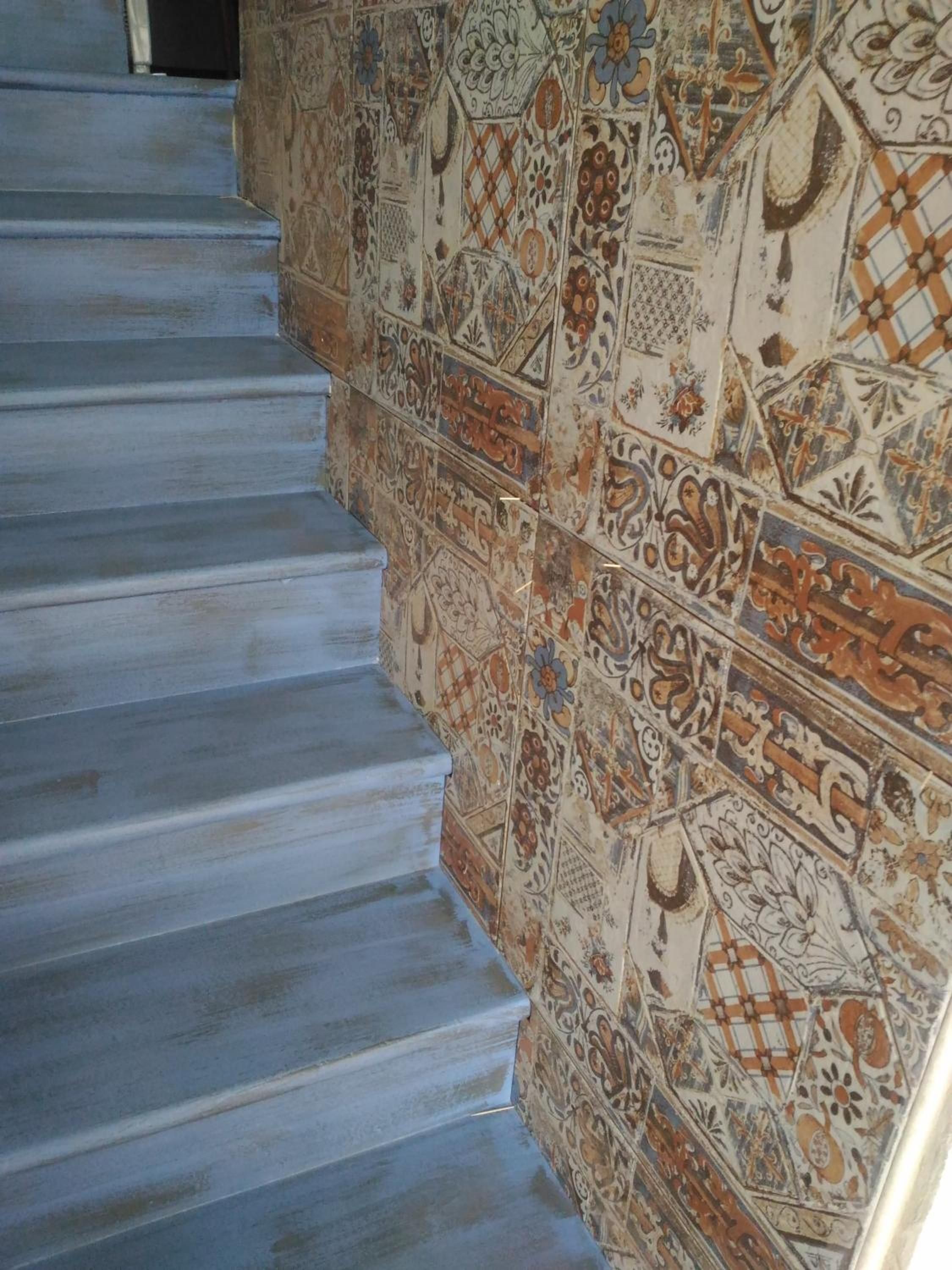 A staircase with a patterned wall on the right side.