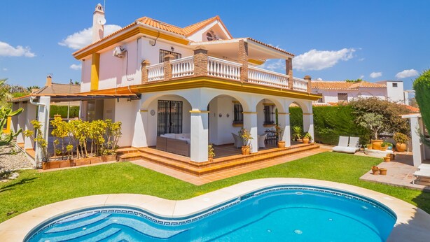 Une maison à deux étages avec une piscine située dans le jardin avant.