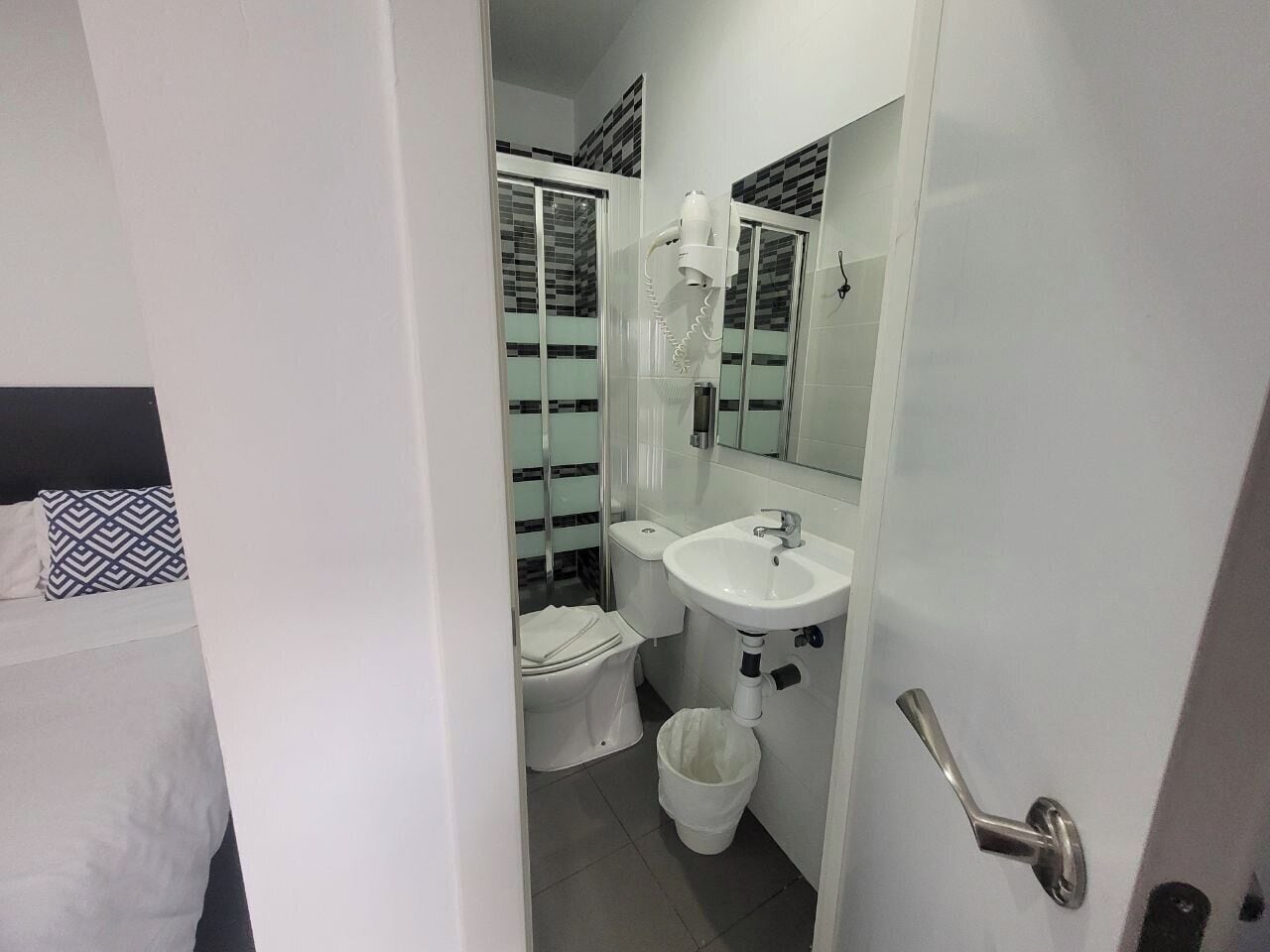 A bathroom with a toilet, sink, and shower.