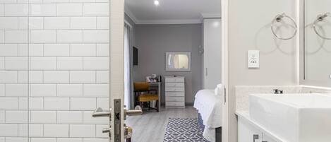 Un baño moderno con lavamanos, espejo y ventilador de techo.
