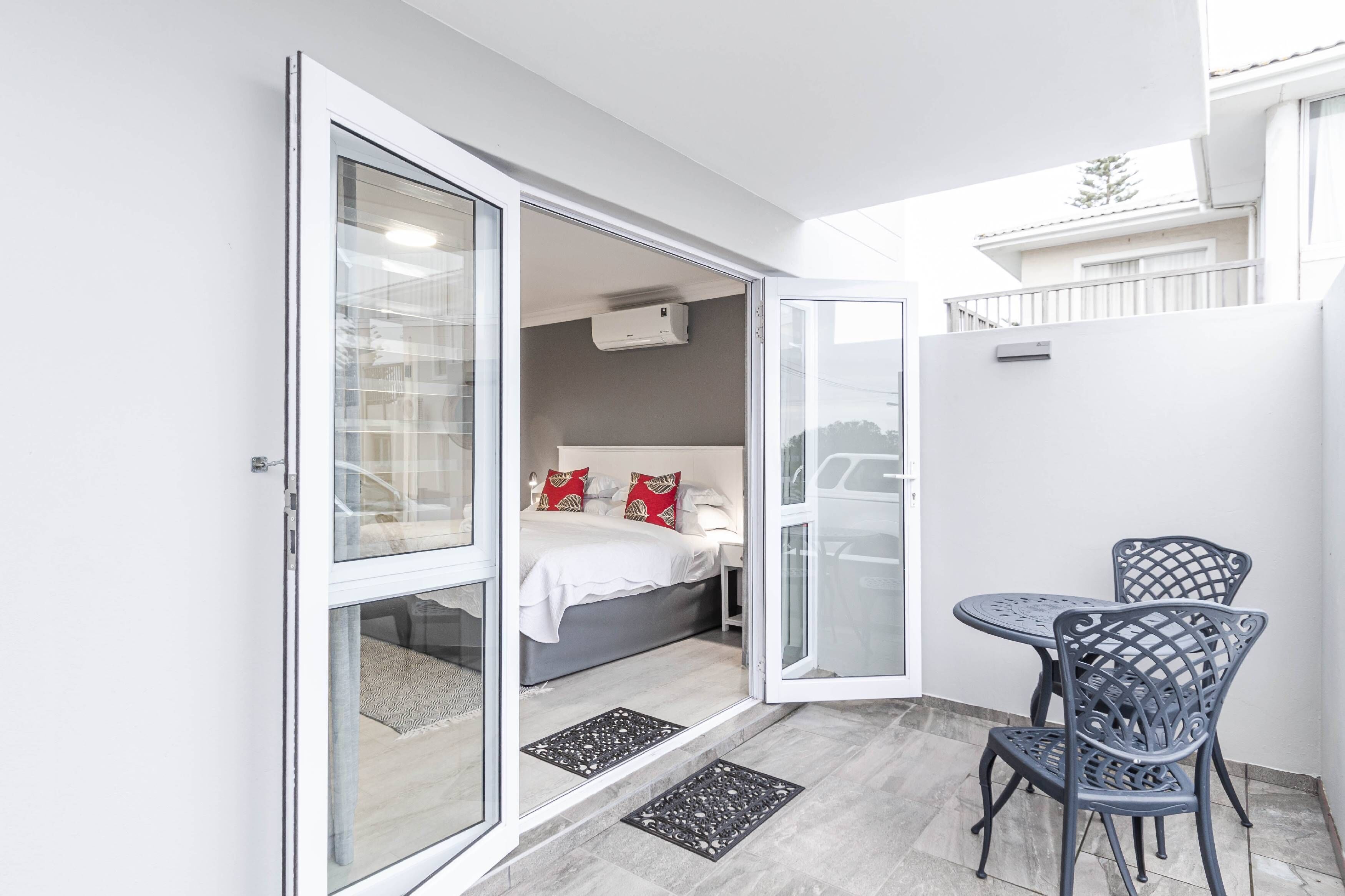 Una habitación pequeña y moderna con una cama, una mesa y sillas.