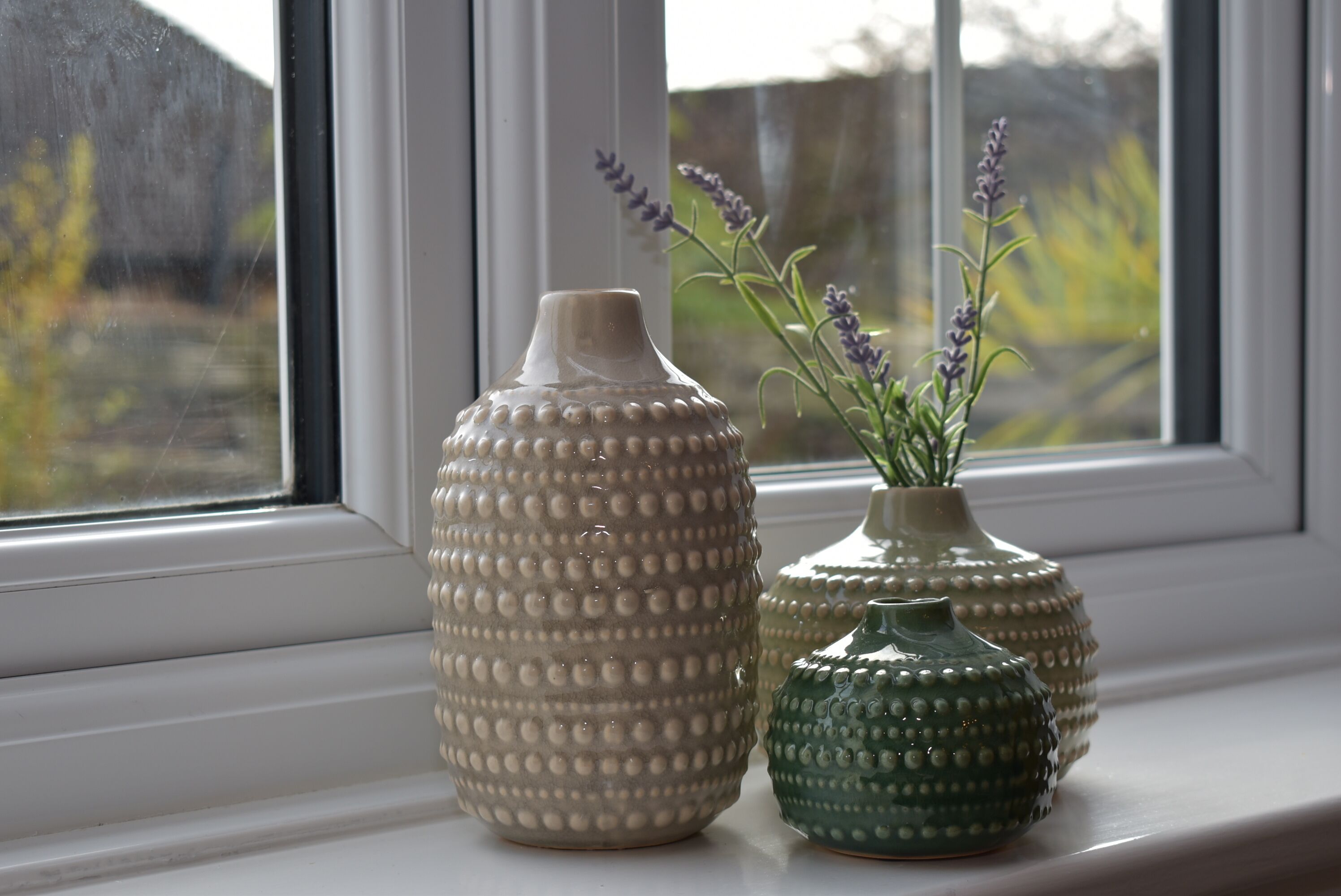 Two ceramic vases on a windowsill.