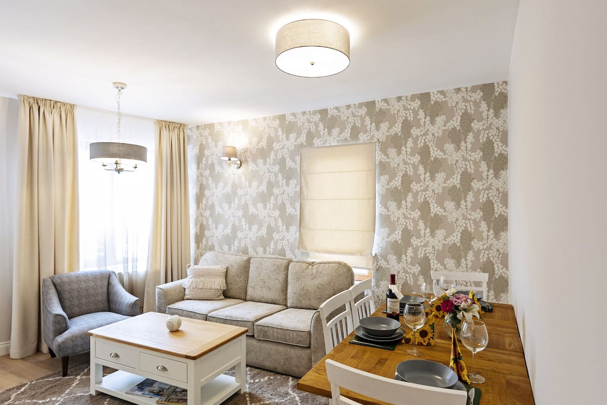 Una sala de estar moderna con un sofá, una mesa de centro y un comedor con una mesa y sillas.