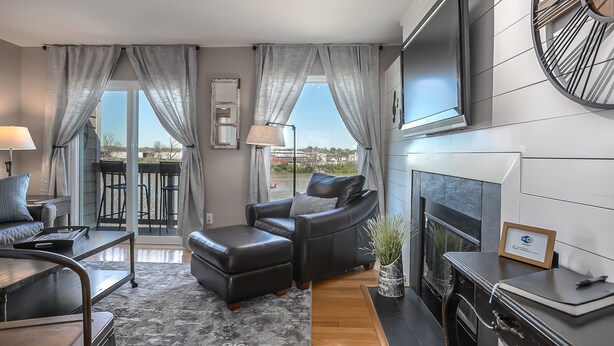 A modern living room with a fireplace, leather sofa, and a view of the city.