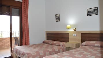 Une chambre d’hôtel avec deux lits, une tête de lit en bois, une petite table de chevet, une lampe et un balcon avec un rideau rouge.