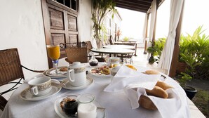 A breakfast setup with a table covered in a white tablecloth, featuring plates, cups, and a glass of orange juice. - Finca Arminda (Villa de Mazo)