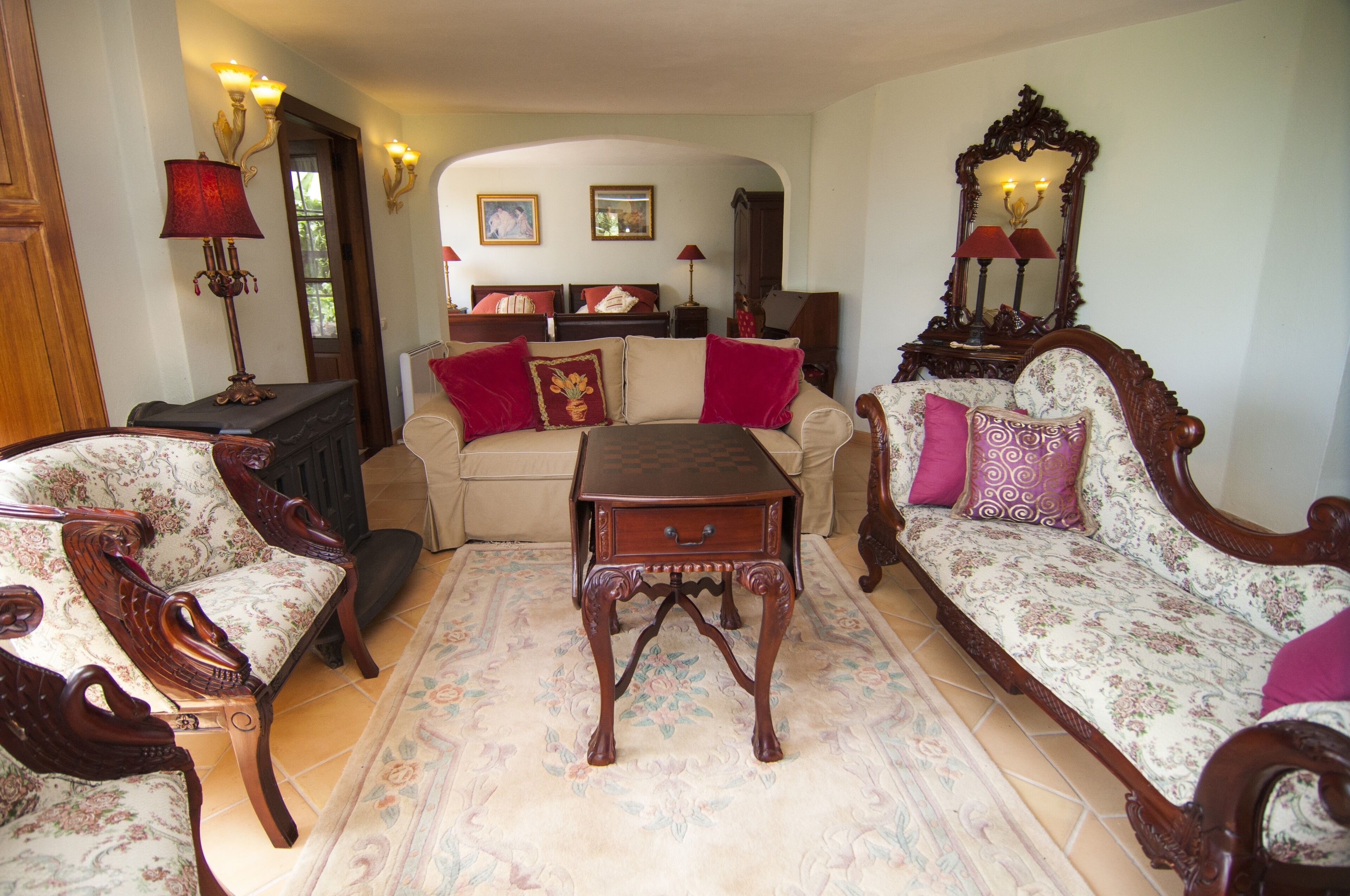 A traditional living room with a sofa, armchairs, a coffee table, and a fireplace.