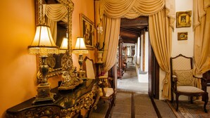 An ornate hallway with a grand mirror, elegant chandeliers, and classic furniture. - Finca Arminda (Villa de Mazo)
