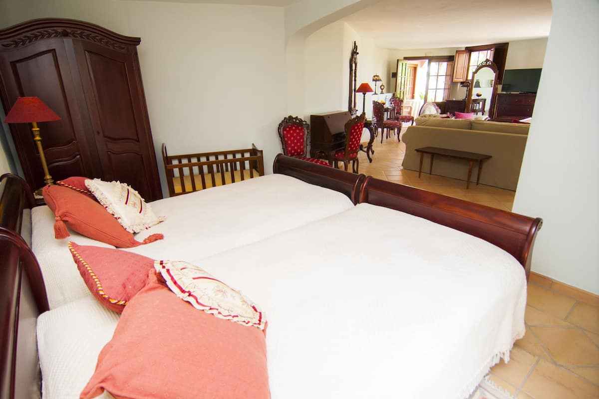 A bedroom with a large bed, wooden headboard, and a wooden bench.