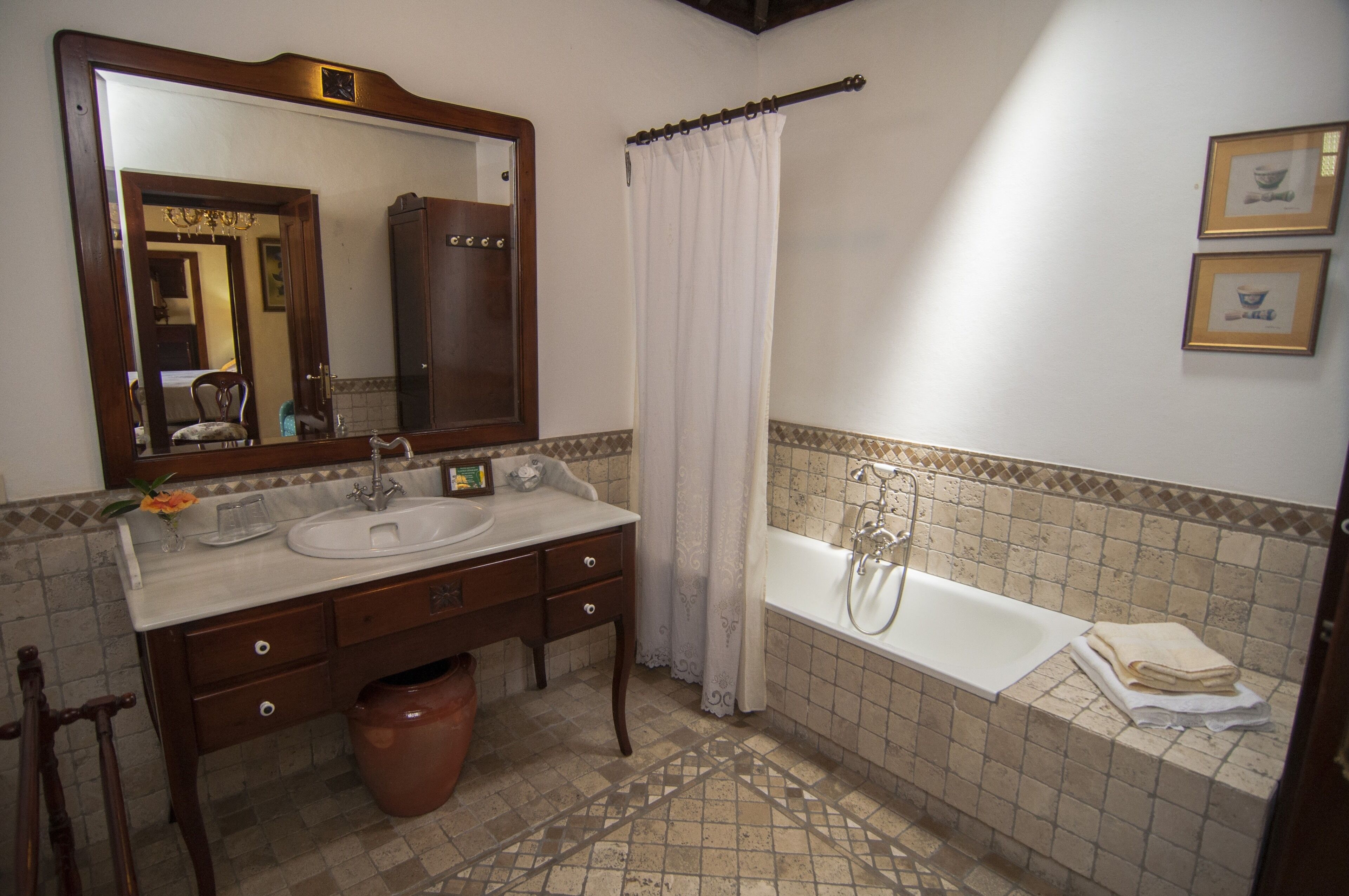 A bathroom with a large mirror, two sinks, a bathtub, and a shower curtain.