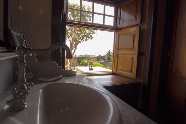 Un baño con lavamanos, ventana y vistas al exterior.