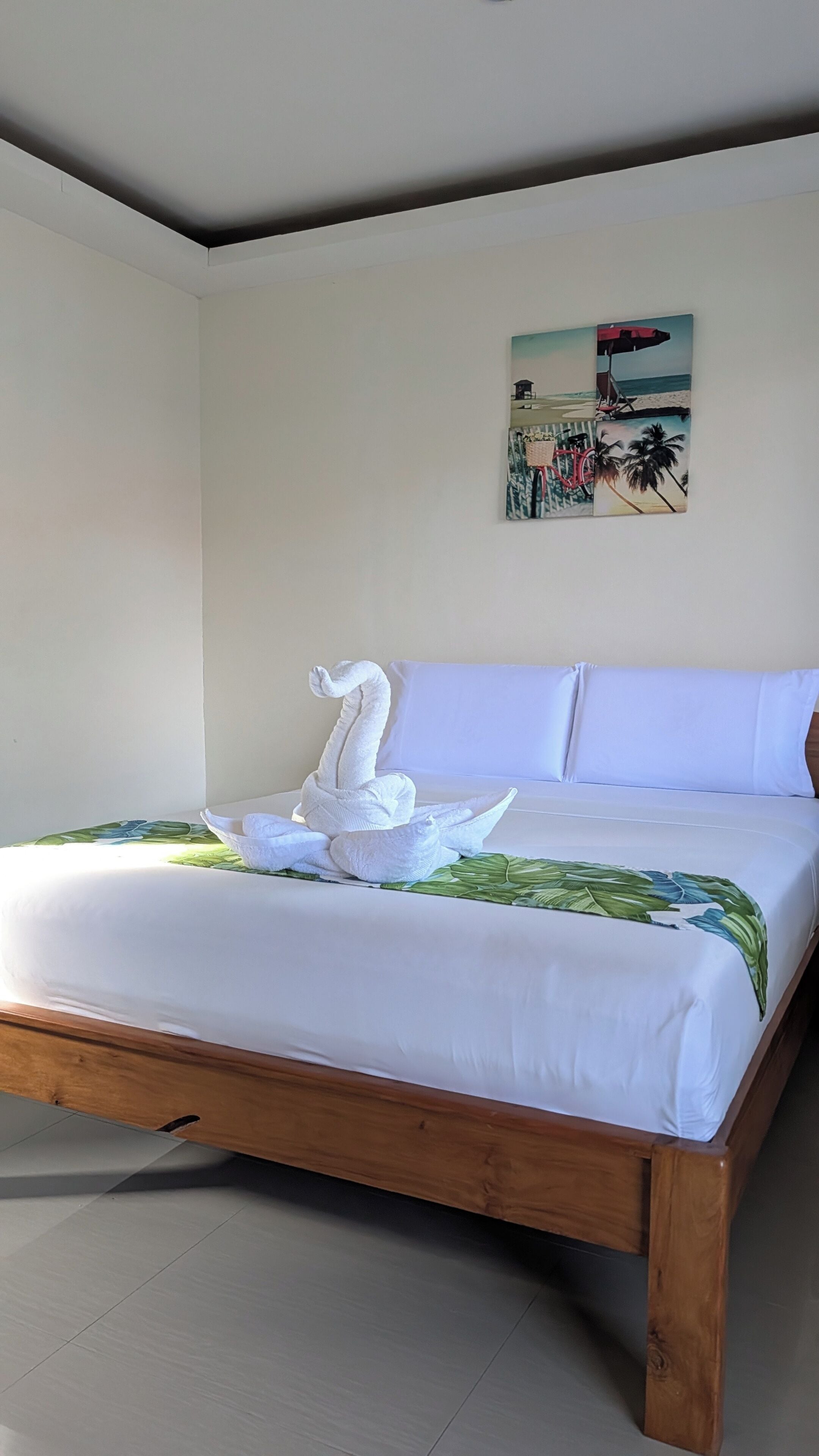 Un dormitorio con una cama, un cuadro y una escultura de toalla.