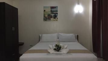 A hotel room with a bed, a nightstand, a wardrobe, and a painting on the wall.