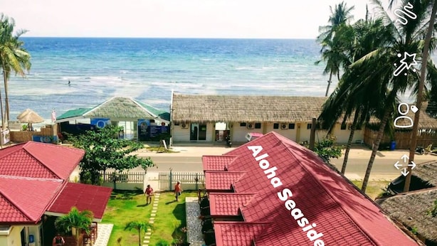 A resort with a swimming pool, palm trees, and a beach view. - Aloha Seaside  Resort (San Juan)