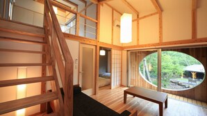 A wooden interior with a staircase, a bench, and a view through a circular window. - Tora no Yu (Kokonoe)