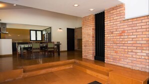 Un espacio habitable amplio con chimenea, una mesa de comedor con sillas y una cocina al fondo.