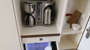 Una kitchenette equipada con cafetera, tostadora y microondas.