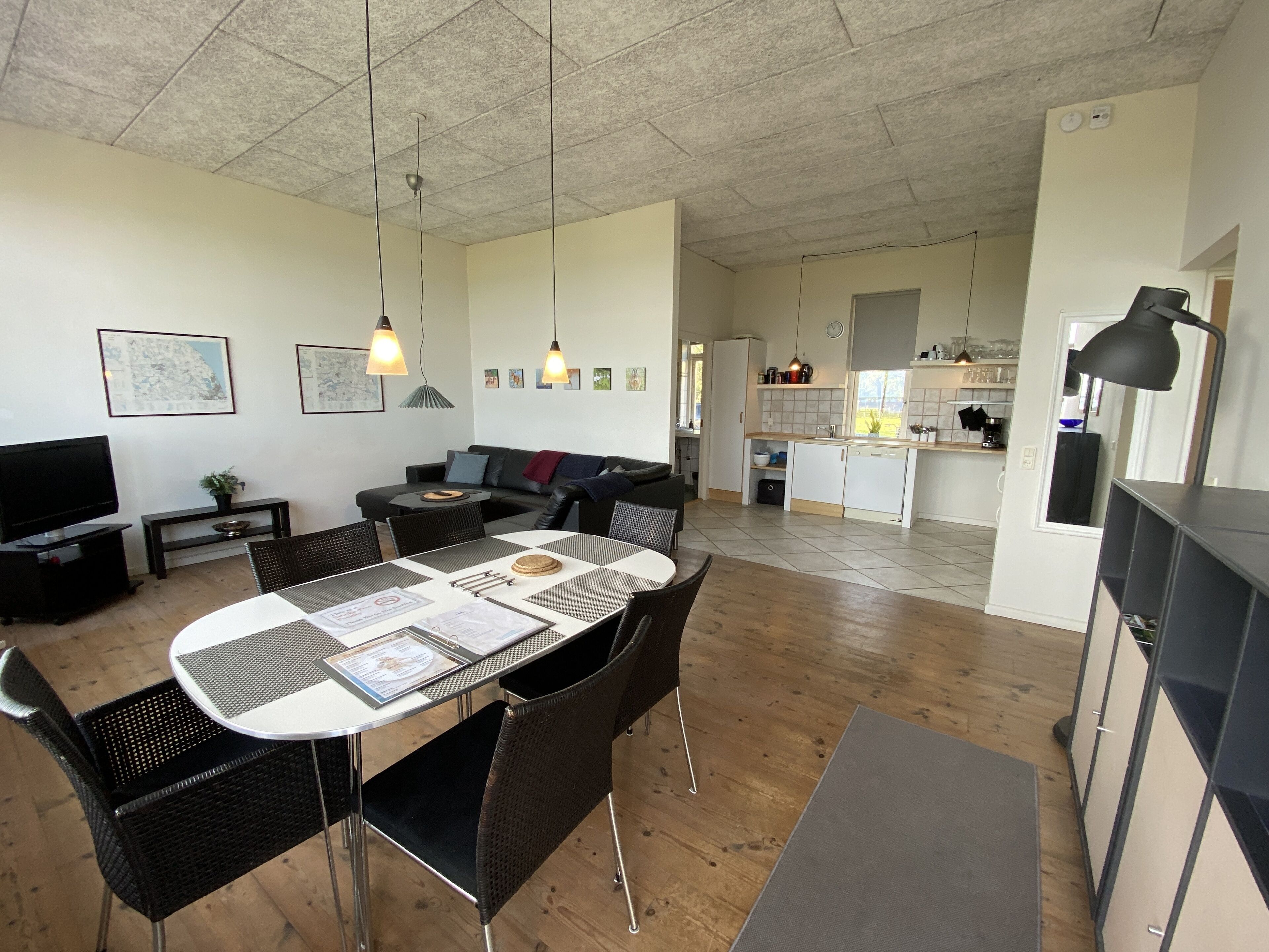 Um apartamento moderno com sala de jantar, cozinha e sala de estar.